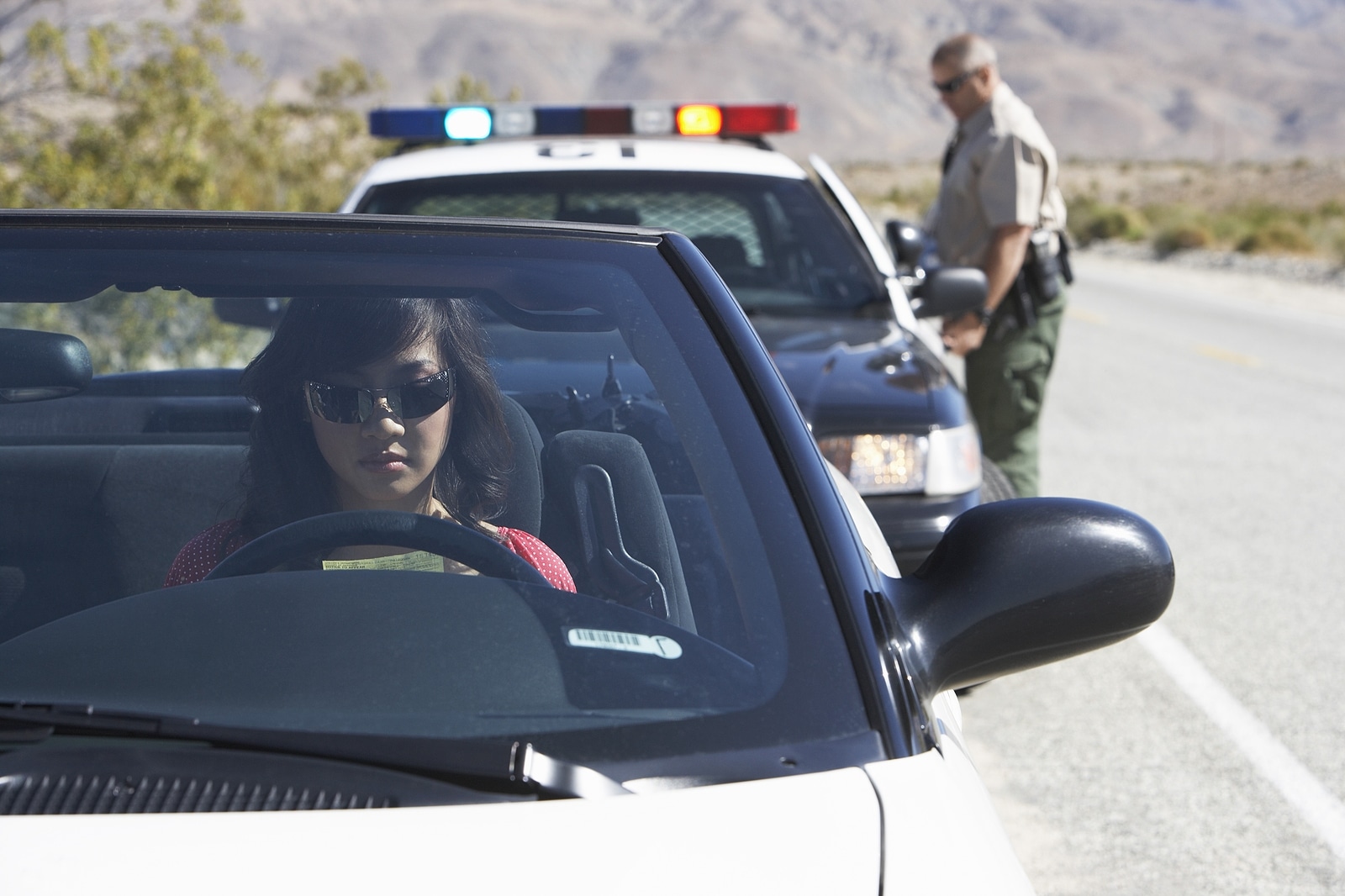 Police officer behind woman in convertible