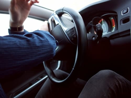 Man inside of car making a sudden move with steering wheel