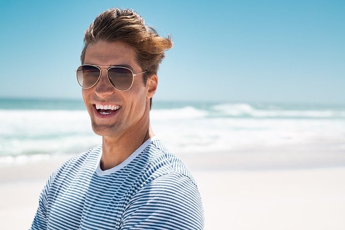 Jimmy in sunglasses standing at the beach