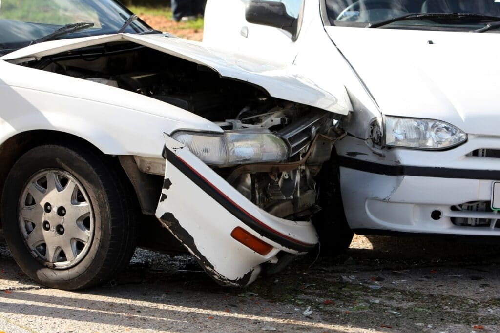  Two damaged cars after an accident on the road with a focus on the front-left of each vehicle.