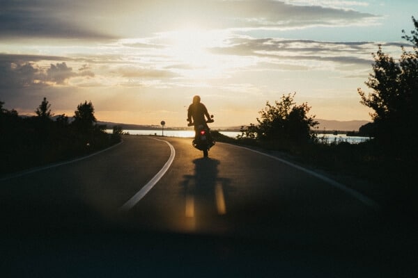 Person riding motorcycle during sunset