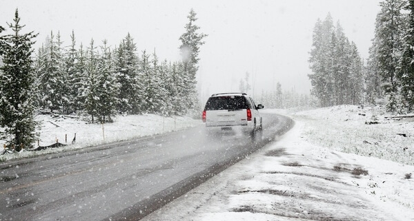 white car driving in the snow