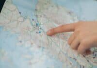 Person pointing to a road on a map